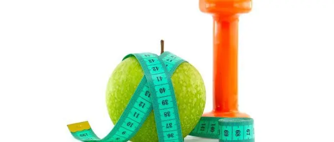 An apple, a hand weight, and a measuring tape.