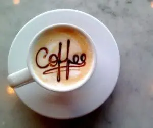 coffee cup on a saucer with coffee spelled out
