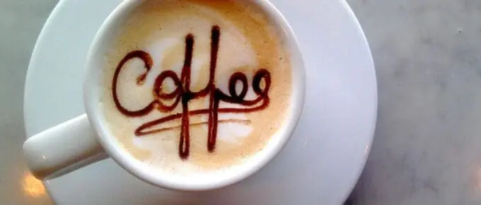 coffee cup on a saucer with coffee spelled out