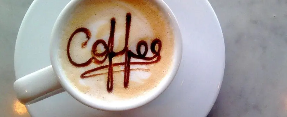 coffee cup on a saucer with coffee spelled out