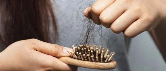 Patient brushing hair—temporary post-bariatric hair shedding (telogen effluvium)”