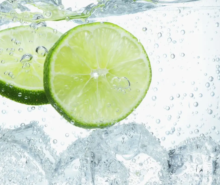 clear drink with bubbles, ice, and lime slices