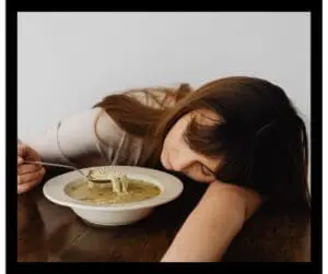 woman asleep while eating soup