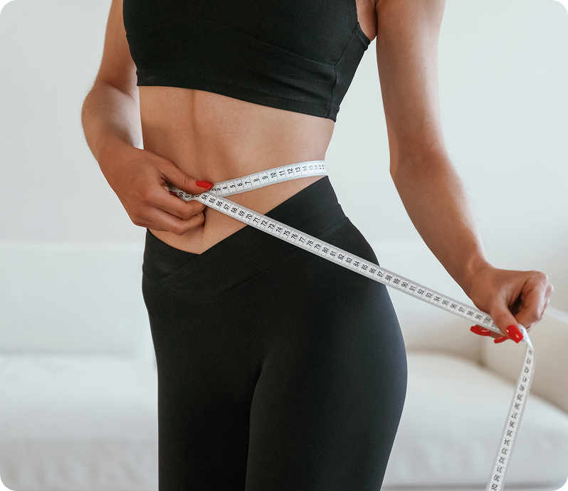 Woman measuring her waist after weight loss