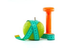 An apple, a hand weight, and a measuring tape.