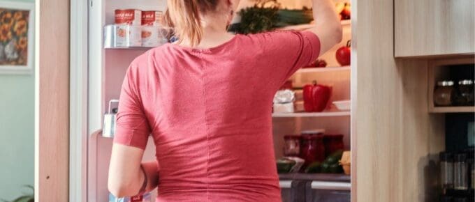 woman standing in front of open fridge door